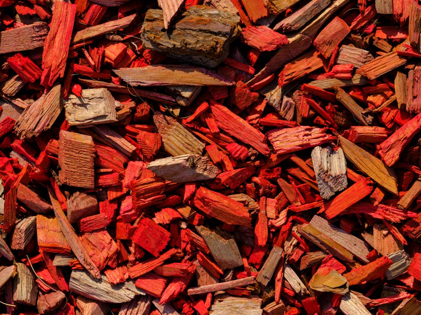 Spreading fresh mulch in a garden bed